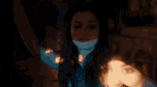 a woman is standing in a dark room with a projector projecting a picture of her face .