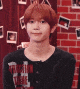 a young man with red hair is wearing a black shirt with the word traction on it