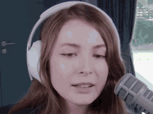 a woman wearing headphones and a white microphone