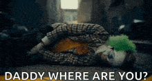 a clown is laying on the ground with the words `` daddy where are you '' written on the bottom .