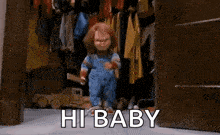a creepy doll is standing in a closet with the words `` hi baby '' written on it .