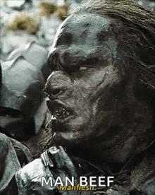 a close up of a man with a beard eating man beef .