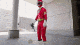 a man dressed as a red carranger holding a gun