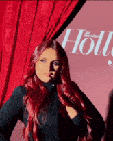 a woman with red hair stands in front of a holly magazine cover