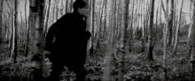 a man is walking through a dark forest .
