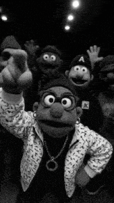 a black and white photo of a group of muppets with one wearing an a hat