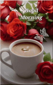 a cup of coffee sits on a saucer next to a bouquet of red roses with the words good morning written above it