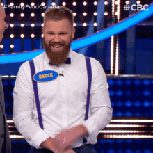 a man with a beard wearing suspenders and a name tag that says brock