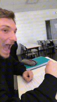 a man is sitting at a table with his mouth open
