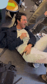 a man is laying on the floor with his mouth open and a black oculus vr headset in the foreground