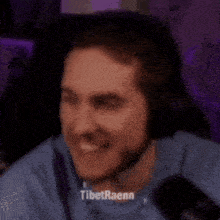 a man wearing headphones is sitting in front of a microphone and making a funny face .