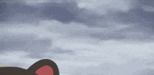 a cartoon cat is standing in front of a cloudy sky with a red ear .