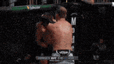 two men are wrestling in a ufc ring with a howler head sign in the background