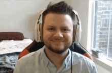 a man with a beard wearing headphones and smiling