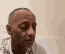 a close up of a man 's face with his eyes closed and a serious look on his face .