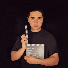 a man holding a clapper board that says production director camera date scene and take