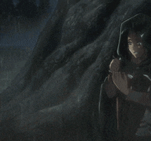 a person in a hooded cape stands in the rain