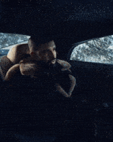 a man in a fur coat is sitting in a car