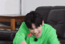 a young man wearing a green shirt with the word fire on it is laughing