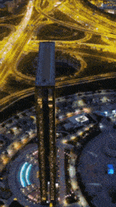 an aerial view of a city at night with a tall building in the middle