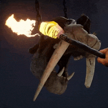 a statue of an elephant 's head is hanging from chains with flames coming out of it