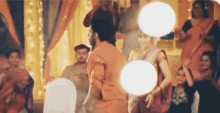 a man and a woman are dancing in front of a crowd of people in a room .