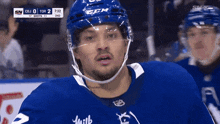 a hockey player wearing a blue helmet with the letter b on it