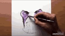 a hand is holding a brush and drawing a face with purple eyes