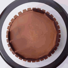 a chocolate cake on a white plate with a black rim