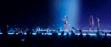a group of people are standing on a stage and one of them is wearing a wig