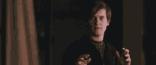 a man in a black jacket is making a funny face with his hands outstretched