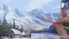 a person is painting a snowy mountain scene with the words made in animotica on the bottom
