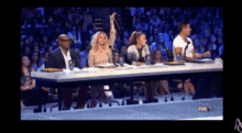 a group of people sitting at a table with a fox logo on the bottom right