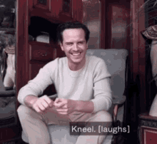 a man sitting in a chair with kneel laughs written below him