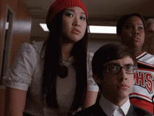 a man wearing glasses sits next to a girl wearing a hs cheerleader shirt