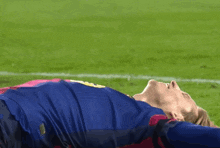 a soccer player is laying on the field with his head on the ground
