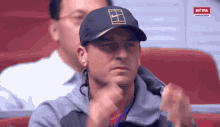 a man wearing a nike hat is sitting in a chair