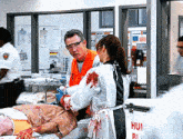 a man in an orange vest is talking to a woman in a white apron in front of a sign that says hun
