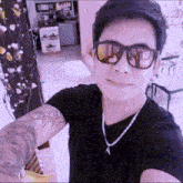 a man wearing sunglasses and a necklace with the letter a