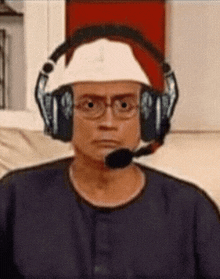 a man is wearing headphones and a hard hat .
