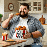 a man is holding a bucket of kfc chicken and french fries