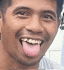 a close up of a man with his tongue out .