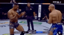 two men are fighting in a boxing ring while a referee stands between them .