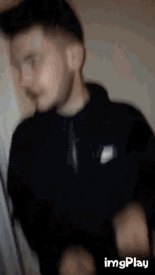 a blurry picture of a man with a beard and a nike logo on his jacket .