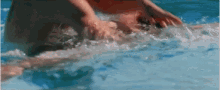 a person is swimming in a pool with their feet in the water