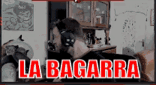 a man wearing headphones sits in a living room with the words la bagarra written in red letters