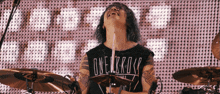 a man playing drums wearing a shirt that says one ok rock