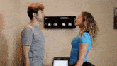 a man and a woman are looking at each other in a room