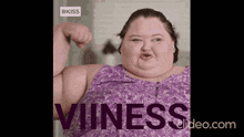 a woman in a purple shirt is flexing her muscles and the word viness is behind her
