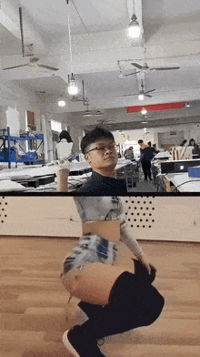 a man in a crop top and shorts is squatting down in a room